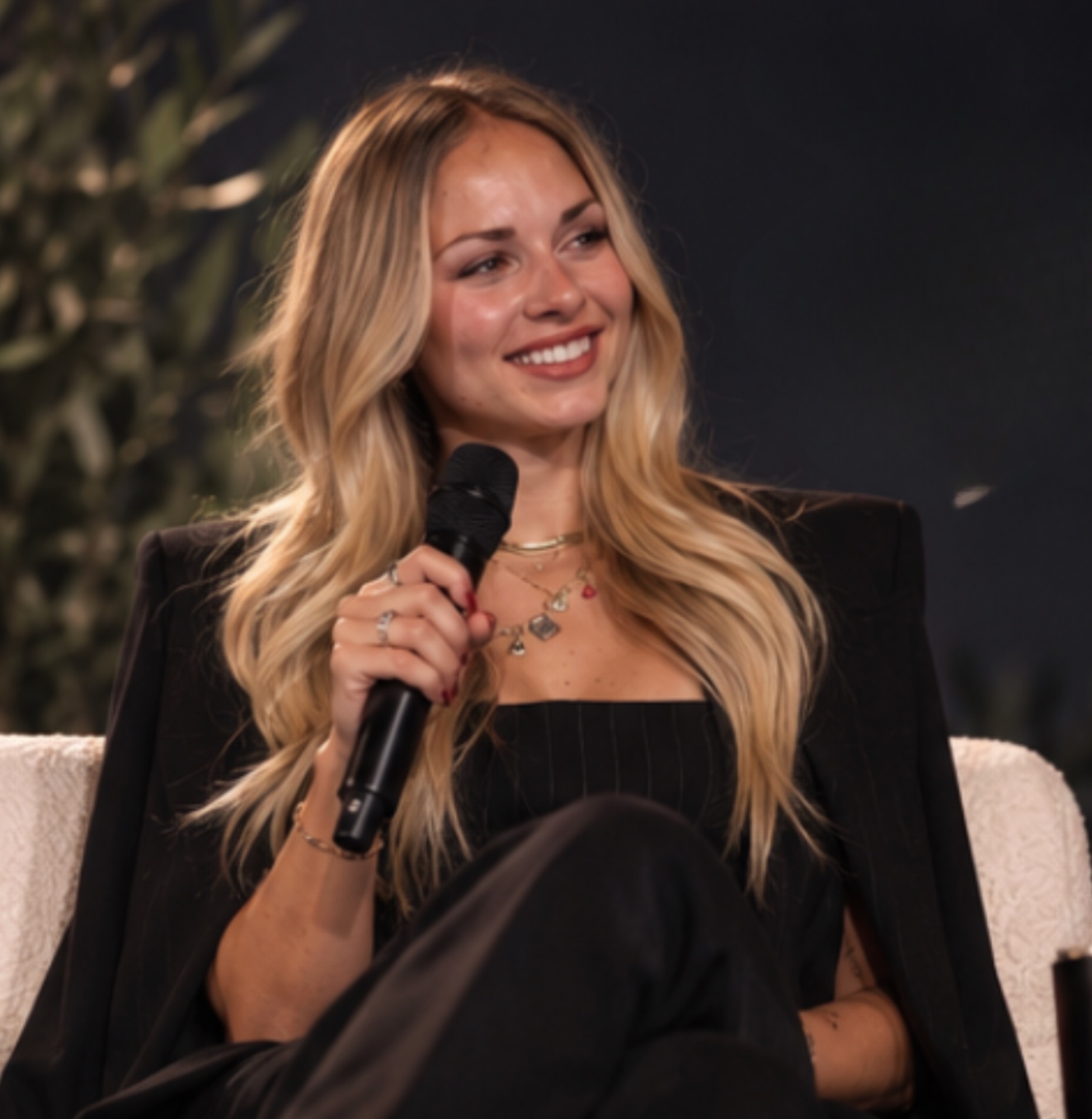 Gabby holding a microphone in a panel setting